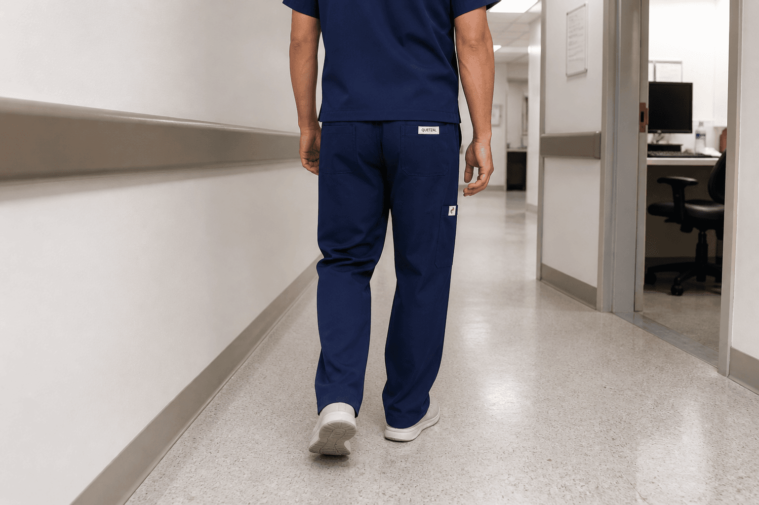 Soignant portant un pantalon bleu nuit QUETZAL dans un couloir